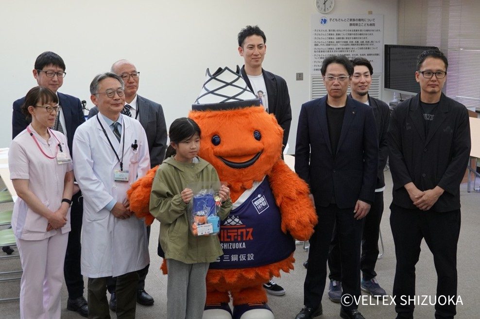 ベルテックス静岡のマスコットキャラクターベルティと記念撮影をする様子